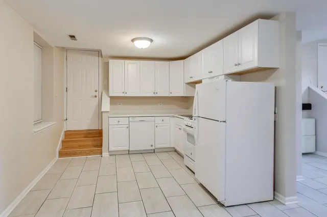 a kitchen with white cabinets and white appliances