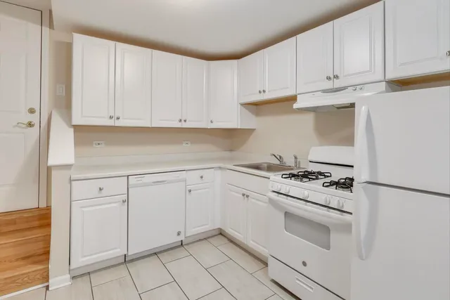 a kitchen with white cabinets and white appliances
