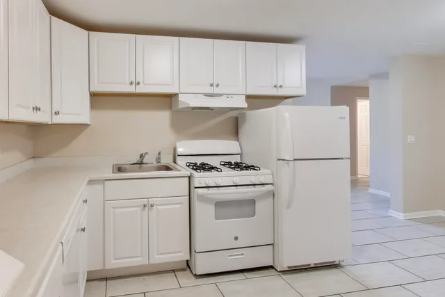 a kitchen with white cabinets and white appliances