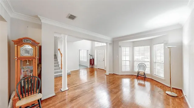 a view of an empty room with wooden floor and a window