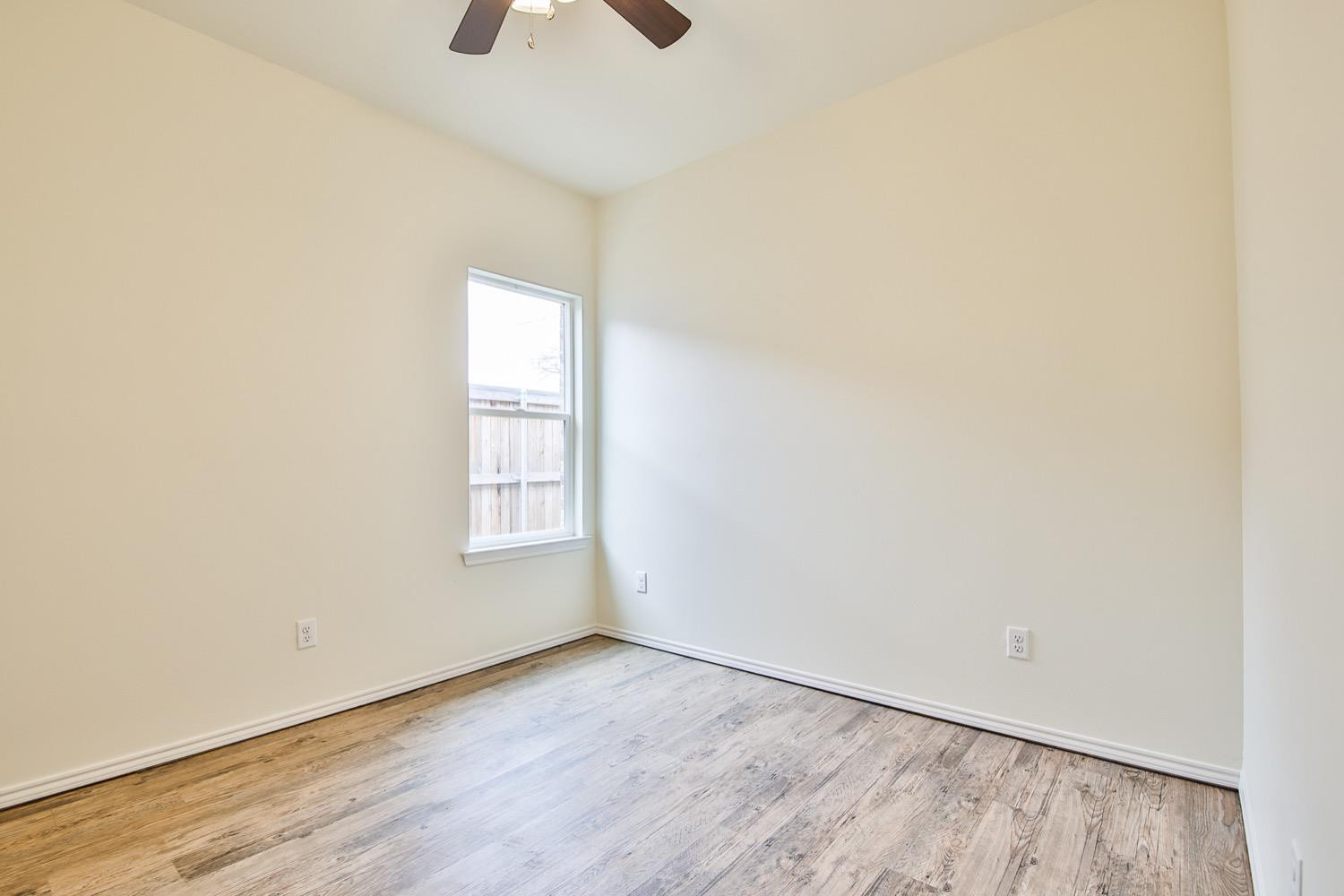 2004 23rd Street Lubbock, TX 79411 - Photo 18 of 26 an empty room with wooden floor and windows