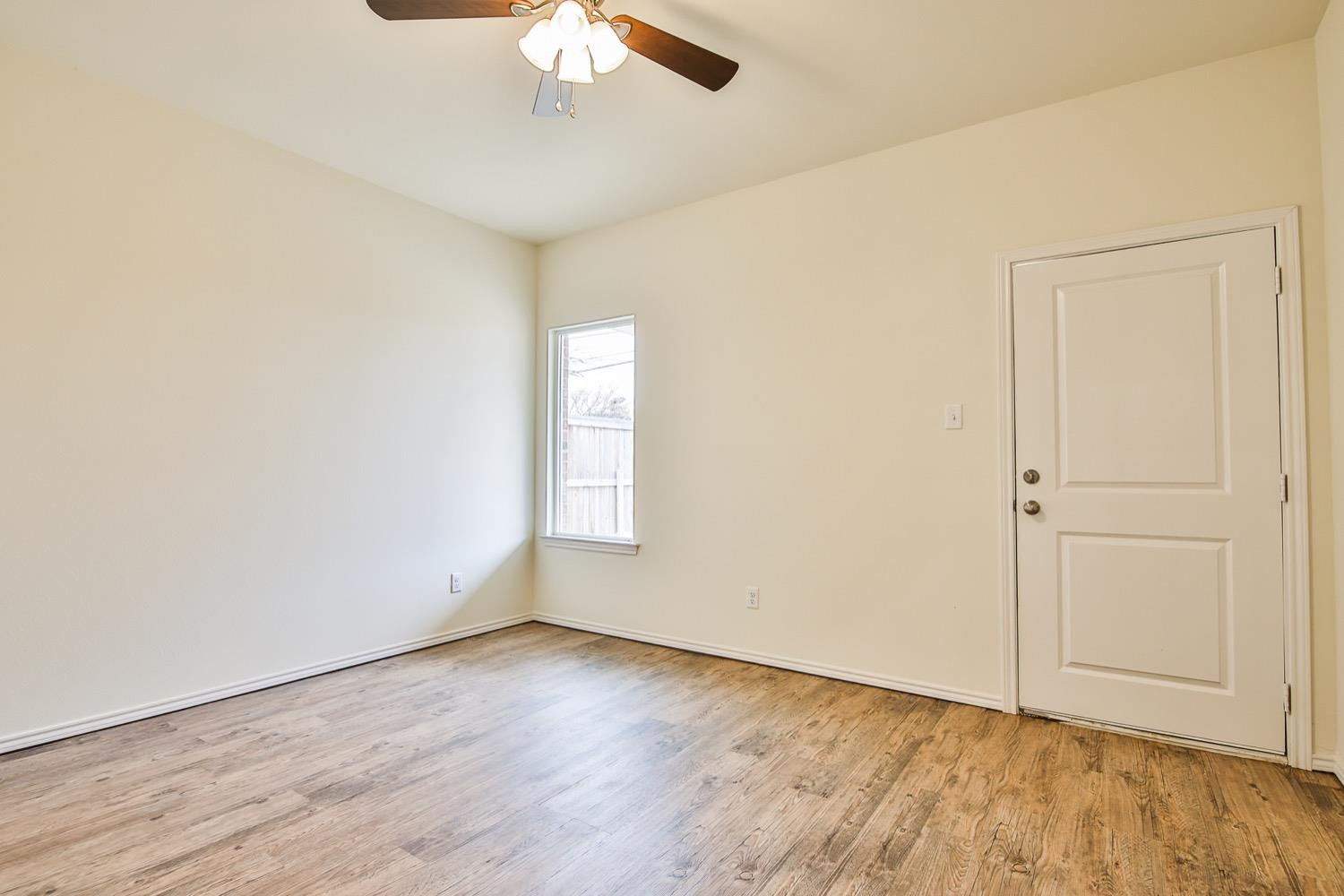 2004 23rd Street Lubbock, TX 79411 - Photo 21 of 26 an empty room with a chandelier fan and windows