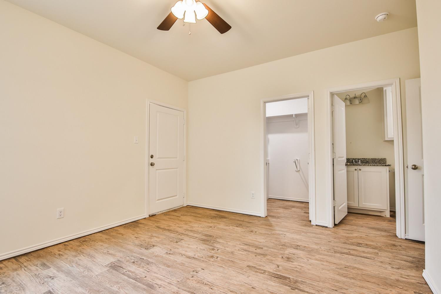 2004 23rd Street Lubbock, TX 79411 - Photo 22 of 26 an empty room with wooden floor cabinet and ceiling fan