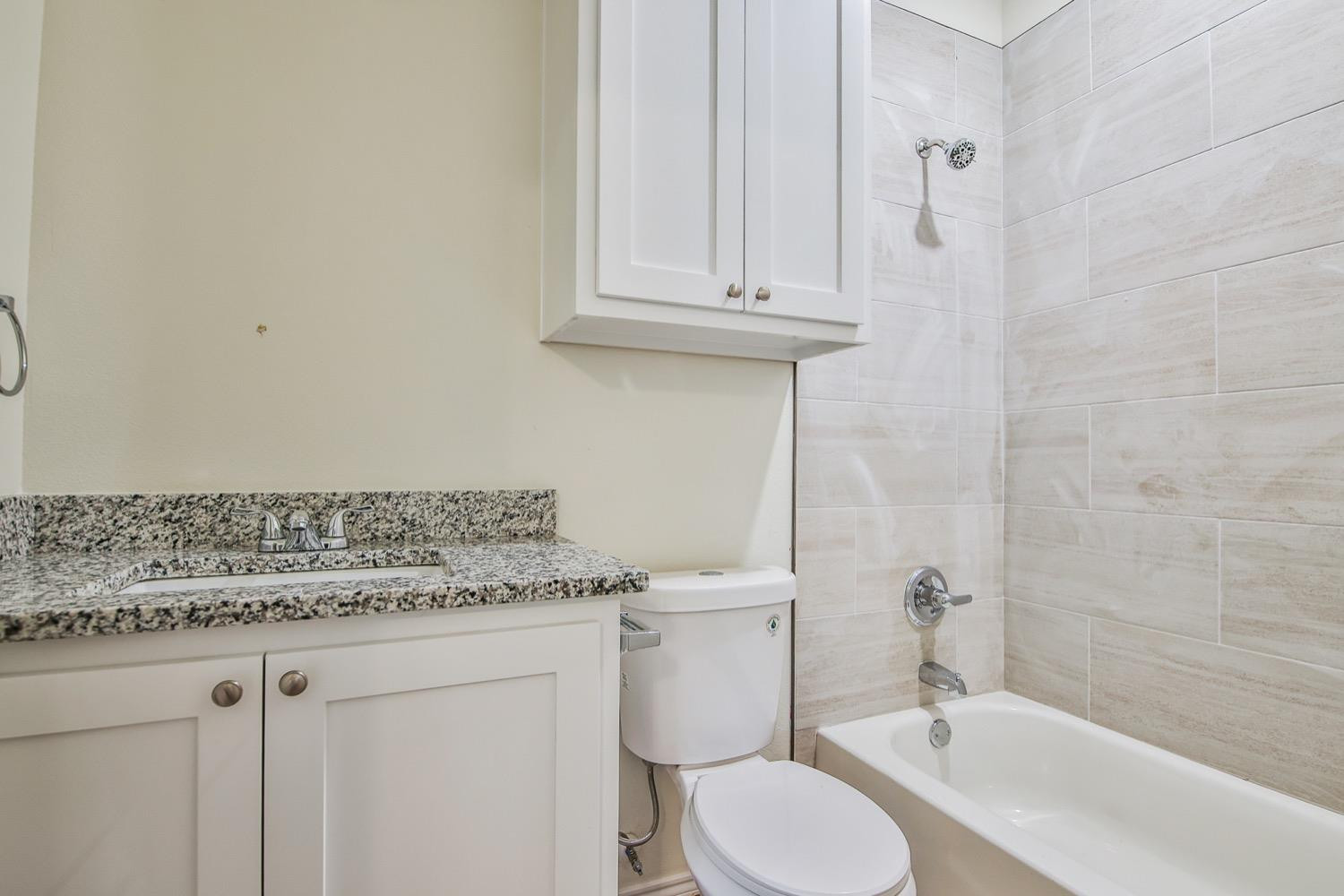 2004 23rd Street Lubbock, TX 79411 - Photo 25 of 26 a bathroom with a granite countertop sink and a toilet