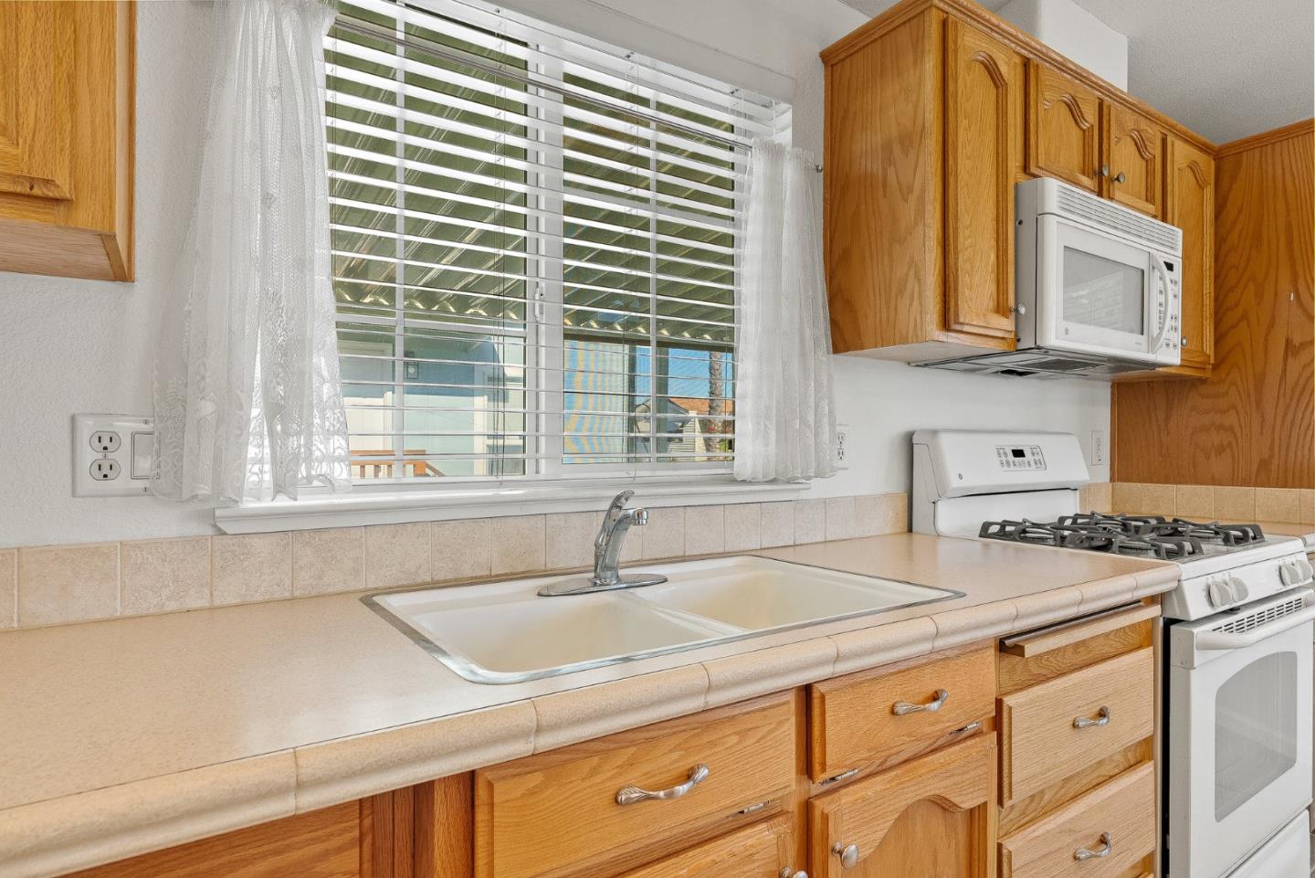 4160 Jade Street, Unit 72 Capitola, CA 95010 - Photo 9 of 23 a kitchen with granite countertop a sink and a window
