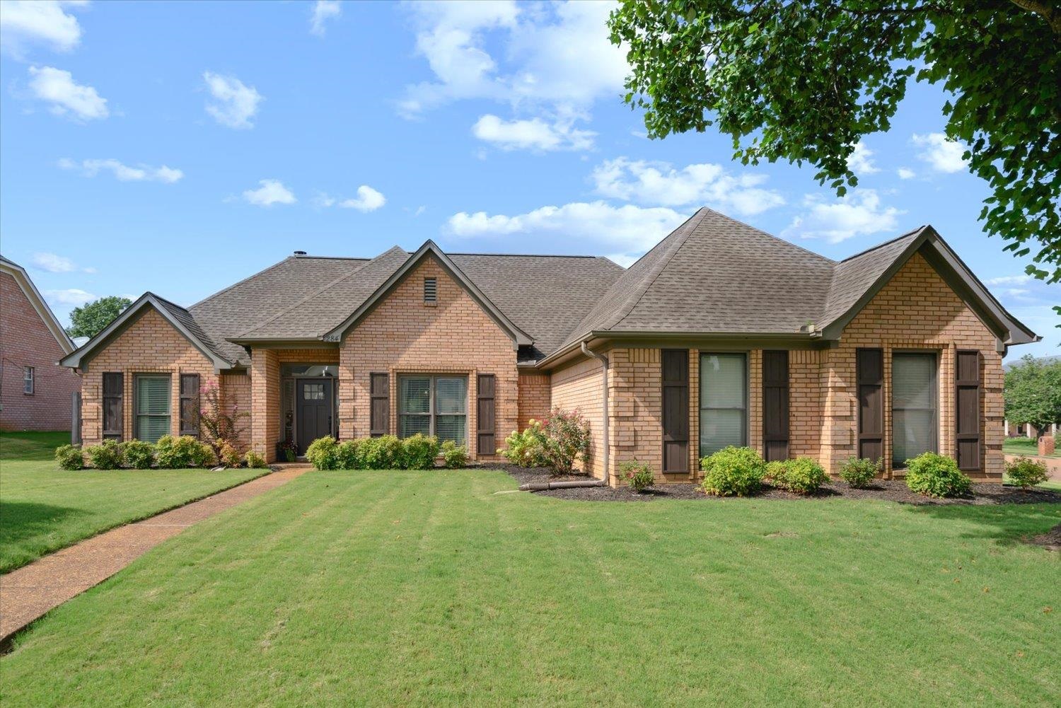a front view of a house with a garden and yard