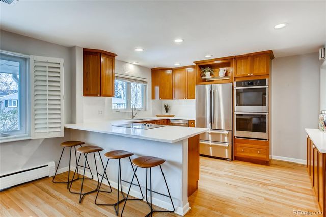 a kitchen with stainless steel appliances granite countertop a refrigerator and a stove top oven