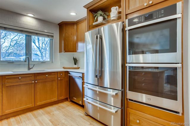 a kitchen with stainless steel appliances a refrigerator and a stove top oven