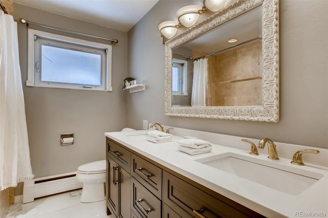 a bathroom with a granite countertop sink a toilet and a mirror
