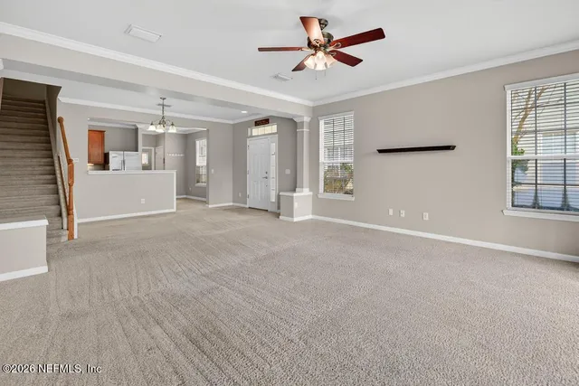 a view of n empty room with window and cabinet