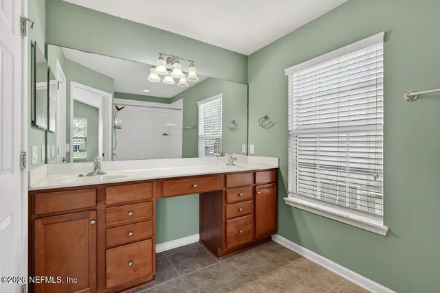 a spacious bathroom with a granite countertop sink and a mirror