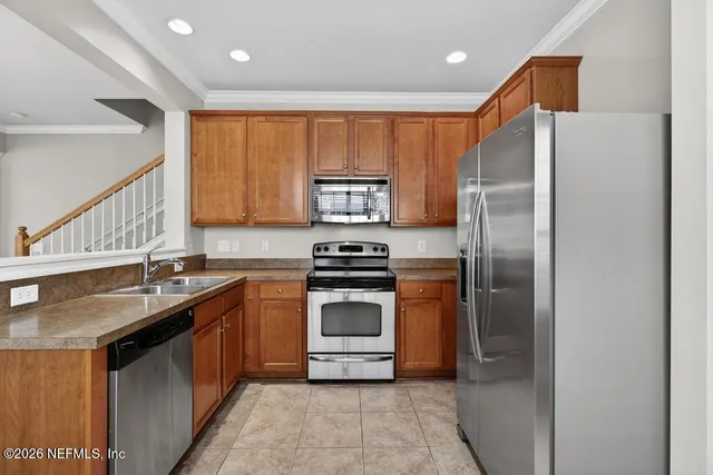 a kitchen with stainless steel appliances granite countertop a stove a refrigerator and a sink