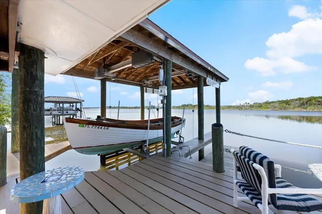 a view of a patio with couches chairs and ocean view