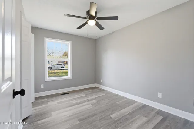 a view of an empty room with a fireplace and a window