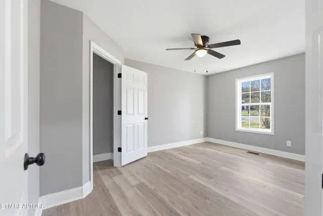 a view of an empty room with a fireplace and a window