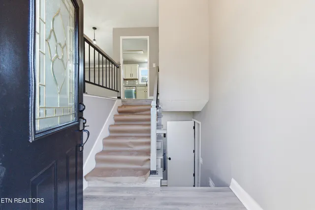 a large white kitchen with wooden floors and a fireplace