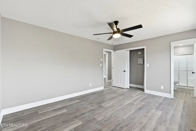 an empty room with wooden floor and windows