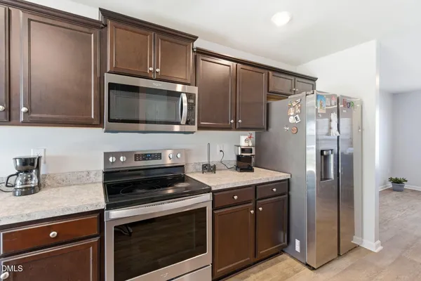 a kitchen with stainless steel appliances granite countertop a stove microwave and refrigerator