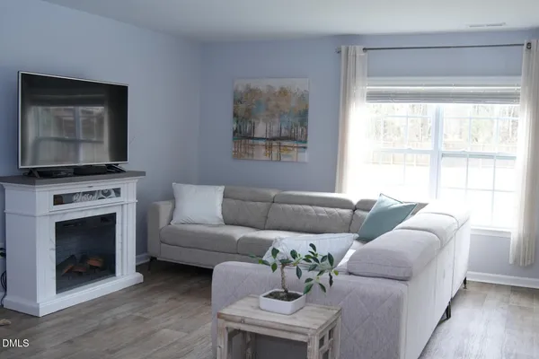 a living room with furniture a fireplace and a flat screen tv