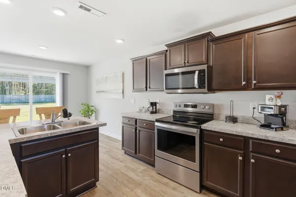 a kitchen with a sink stove and microwave