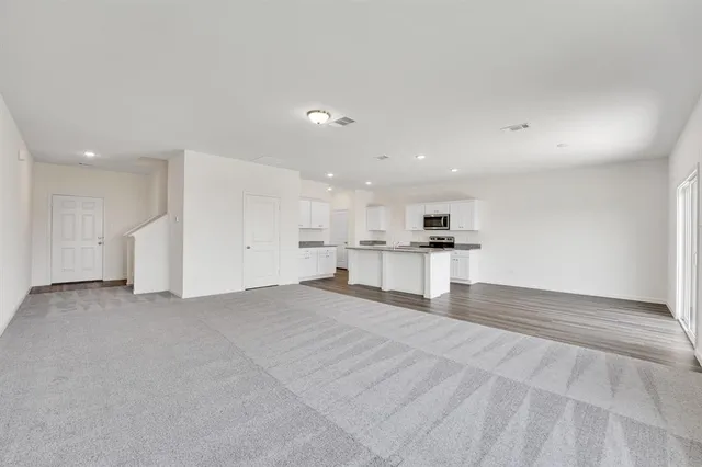 a view of large kitchen with a refrigerator and a stove top oven