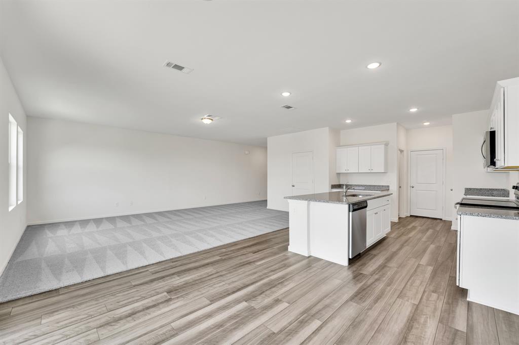 1707 Washington Street Princeton, TX 75407 - Photo 6 of 21 a kitchen with stainless steel appliances kitchen island granite countertop a stove a sink and a refrigerator
