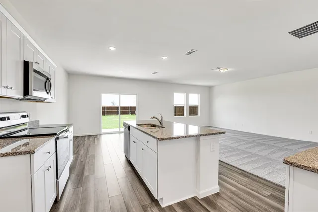 a kitchen with stainless steel appliances granite countertop a sink stove and refrigerator