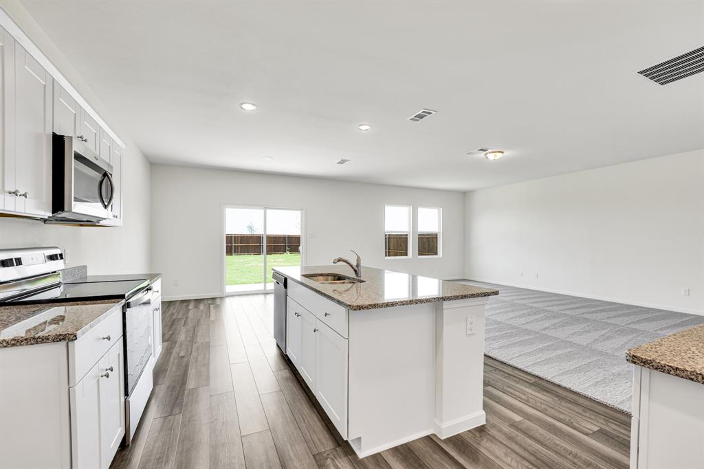1707 Washington Street Princeton, TX 75407 - Photo 7 of 21 a kitchen with stainless steel appliances granite countertop a sink stove and refrigerator