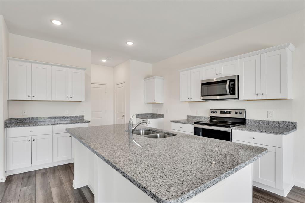 1707 Washington Street Princeton, TX 75407 - Photo 8 of 21 a kitchen with granite countertop a sink stove and microwave