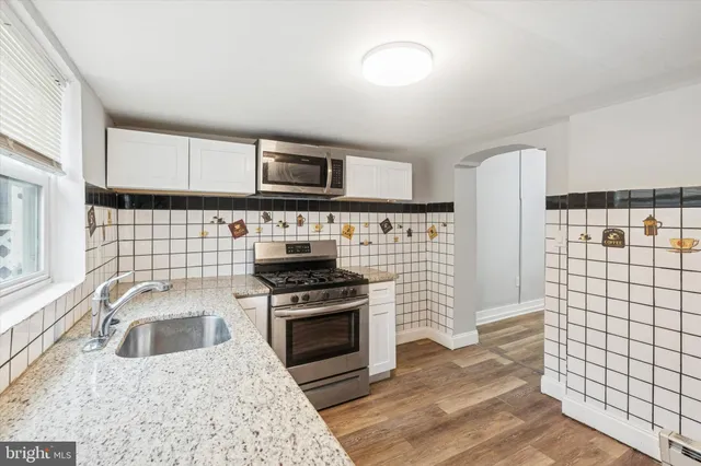 a kitchen with a stove a sink and a microwave