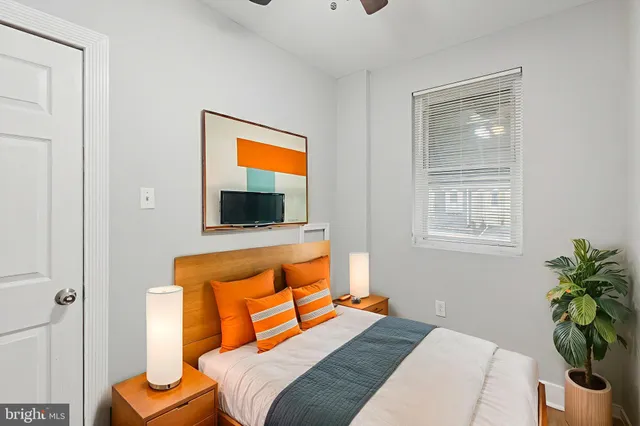 a bedroom with a bed and potted plant