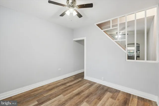 a view of an empty room with wooden floor and windows