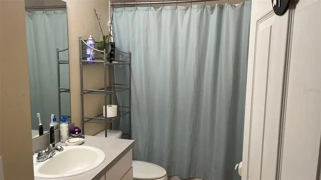 a bathroom with a sink vanity mirror and toilet