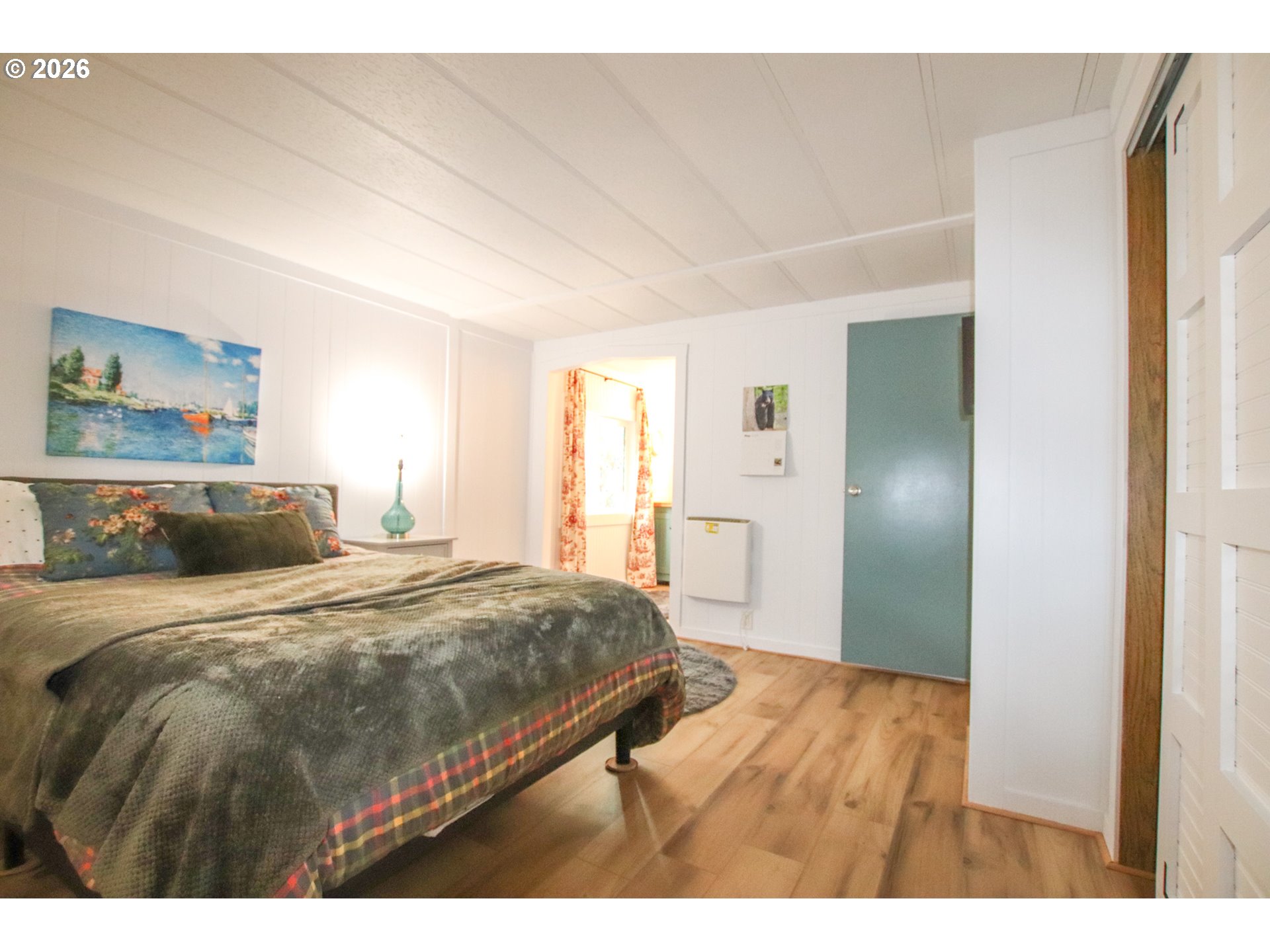1431 Maple Street Florence, OR 97439 - Photo 27 of 43 a bedroom with a bed and wooden floor