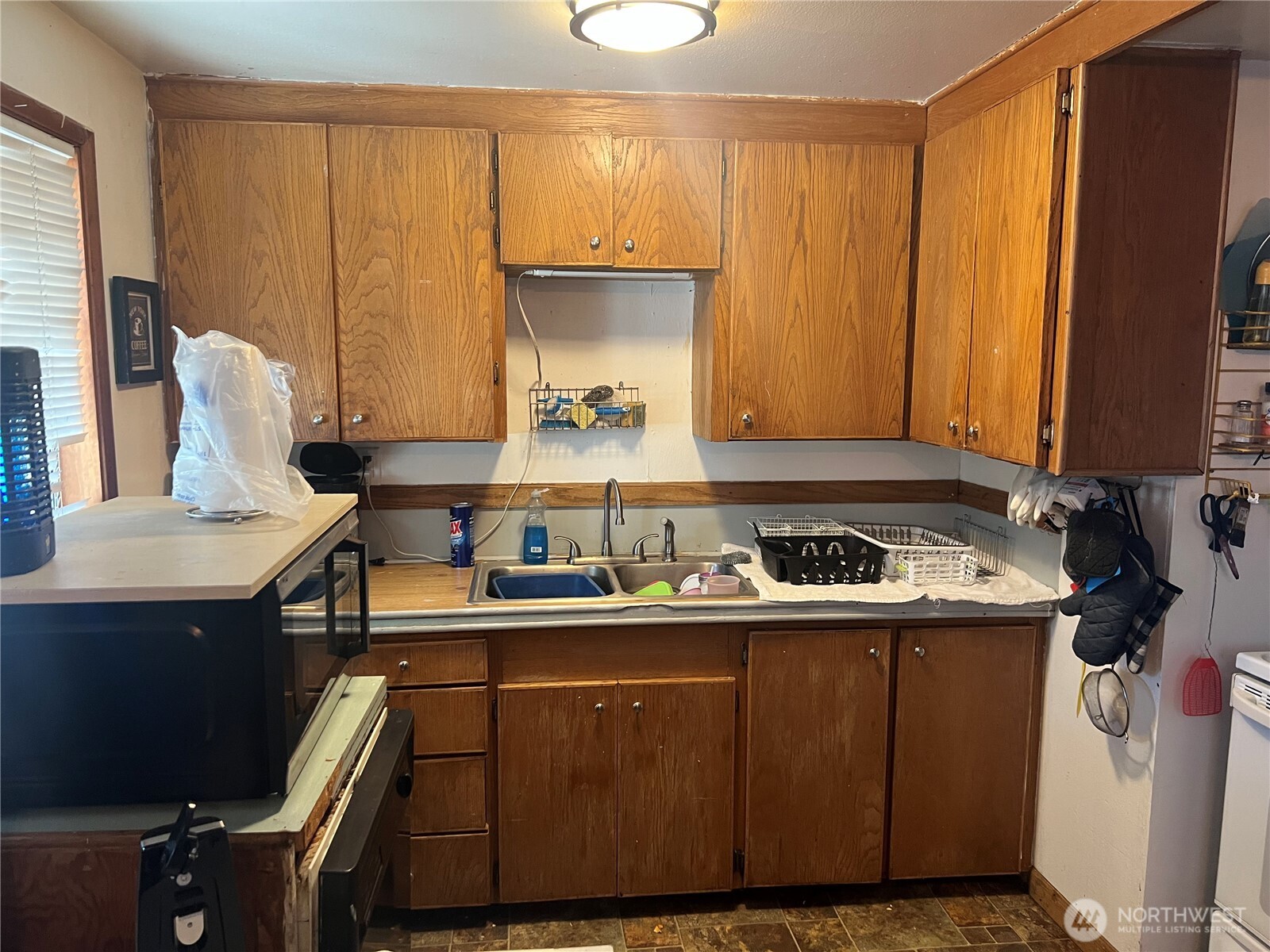 321 West Loop Drive Moses Lake, WA 98837 - Photo 5 of 23 a kitchen with a sink a stove cabinets and wooden floor
