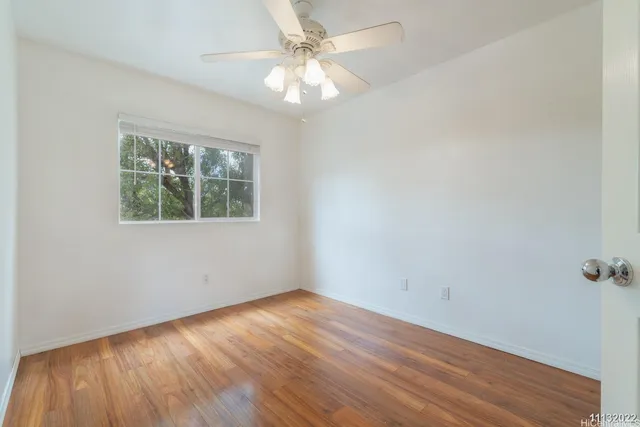 a view of an empty room with wooden floor