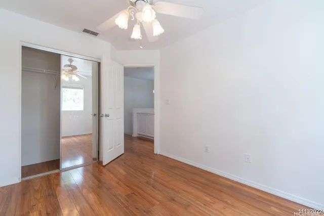 a view of a hallway with wooden floor and chandelier