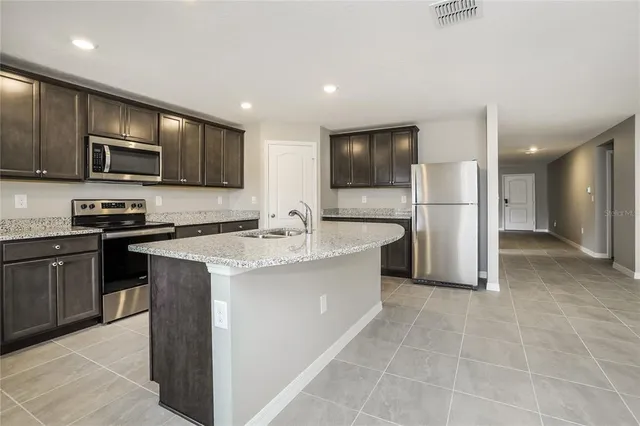 a kitchen with kitchen island a sink appliances and cabinets