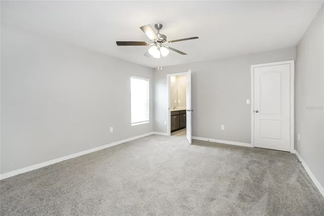 a view of an empty room with a ceiling fan and a window