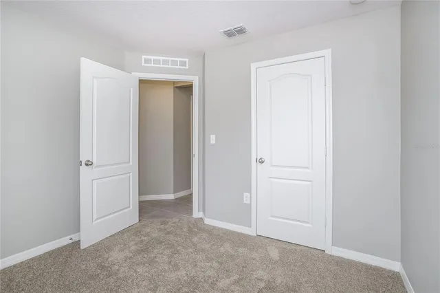 an empty room that has a wooden cupboard
