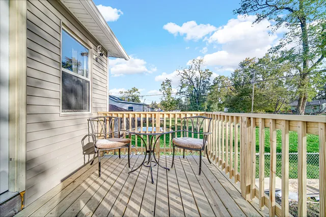 a balcony with wooden floor table and chairs