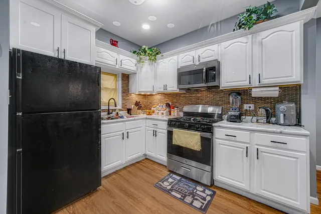 a kitchen with a refrigerator stove and white cabinets