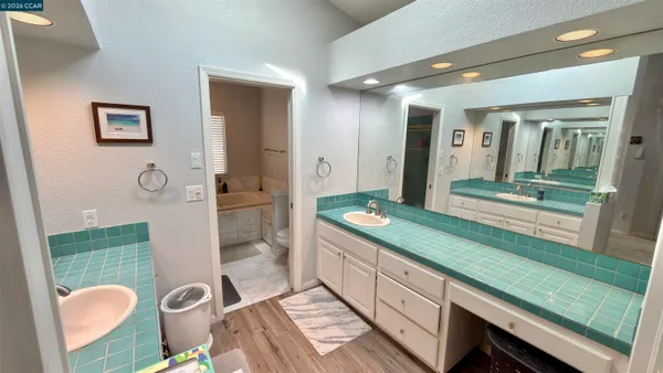 a bathroom with a tub sink and a mirror