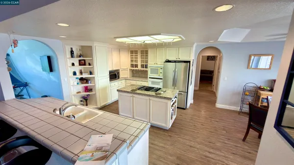 a kitchen with stainless steel appliances wooden floor dining table and chairs