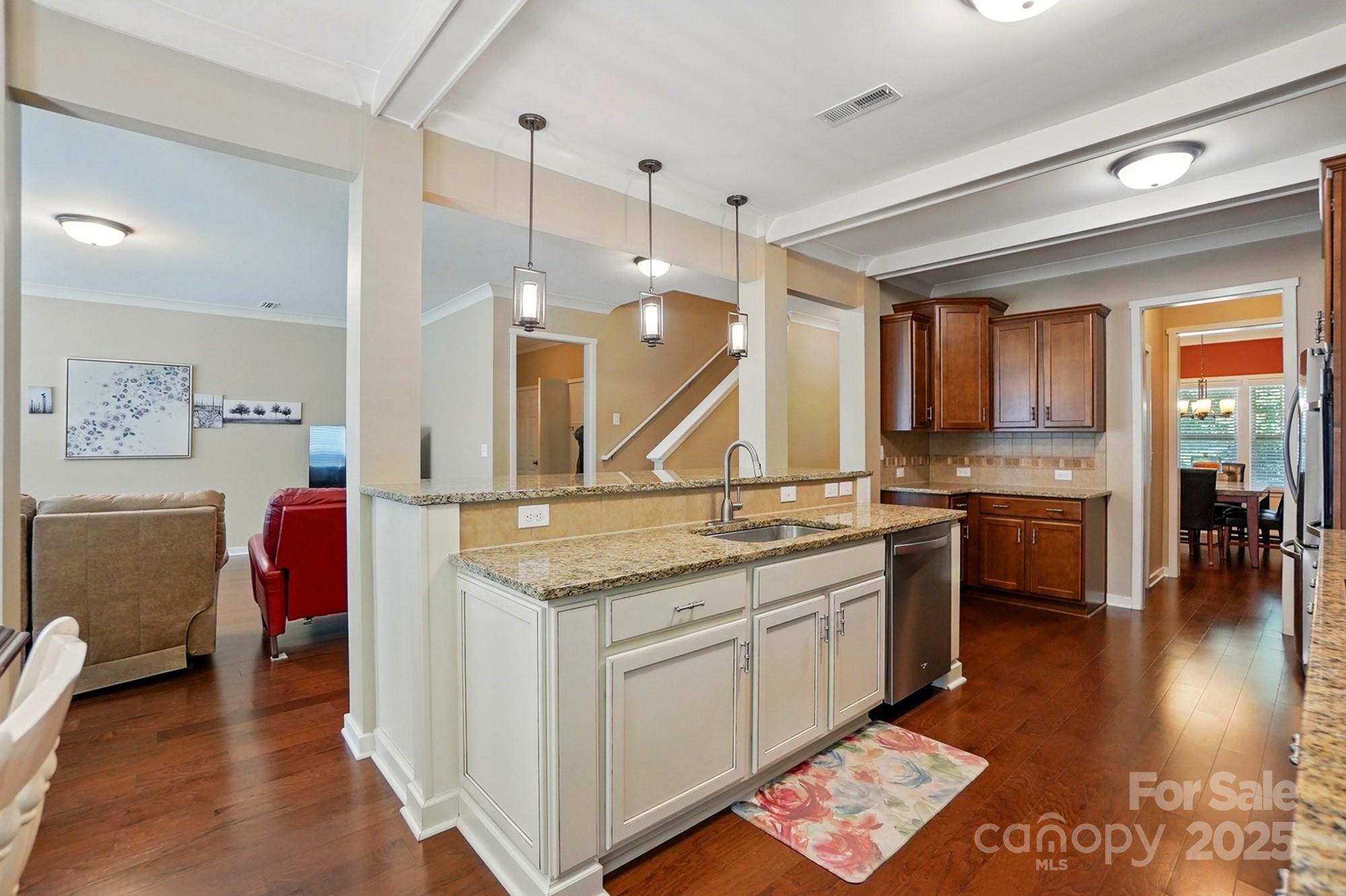 3106 Crosswind Drive Fort Mill, SC 29707 - Photo 20 of 43 a open kitchen with stainless steel appliances granite countertop a sink dishwasher stove and oven with wooden floor