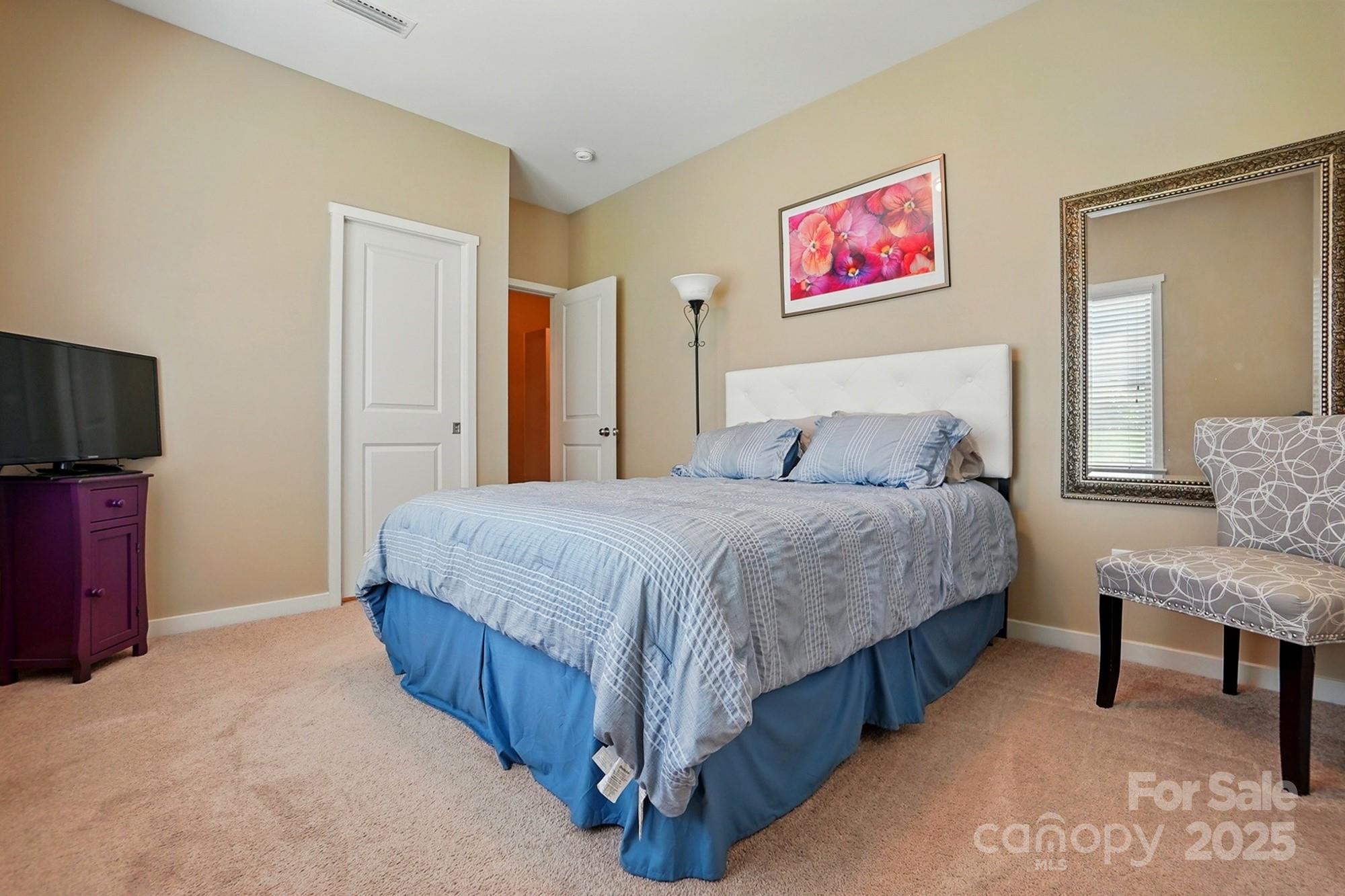 3106 Crosswind Drive Fort Mill, SC 29707 - Photo 23 of 43 a spacious bedroom with a bed and a flat screen tv