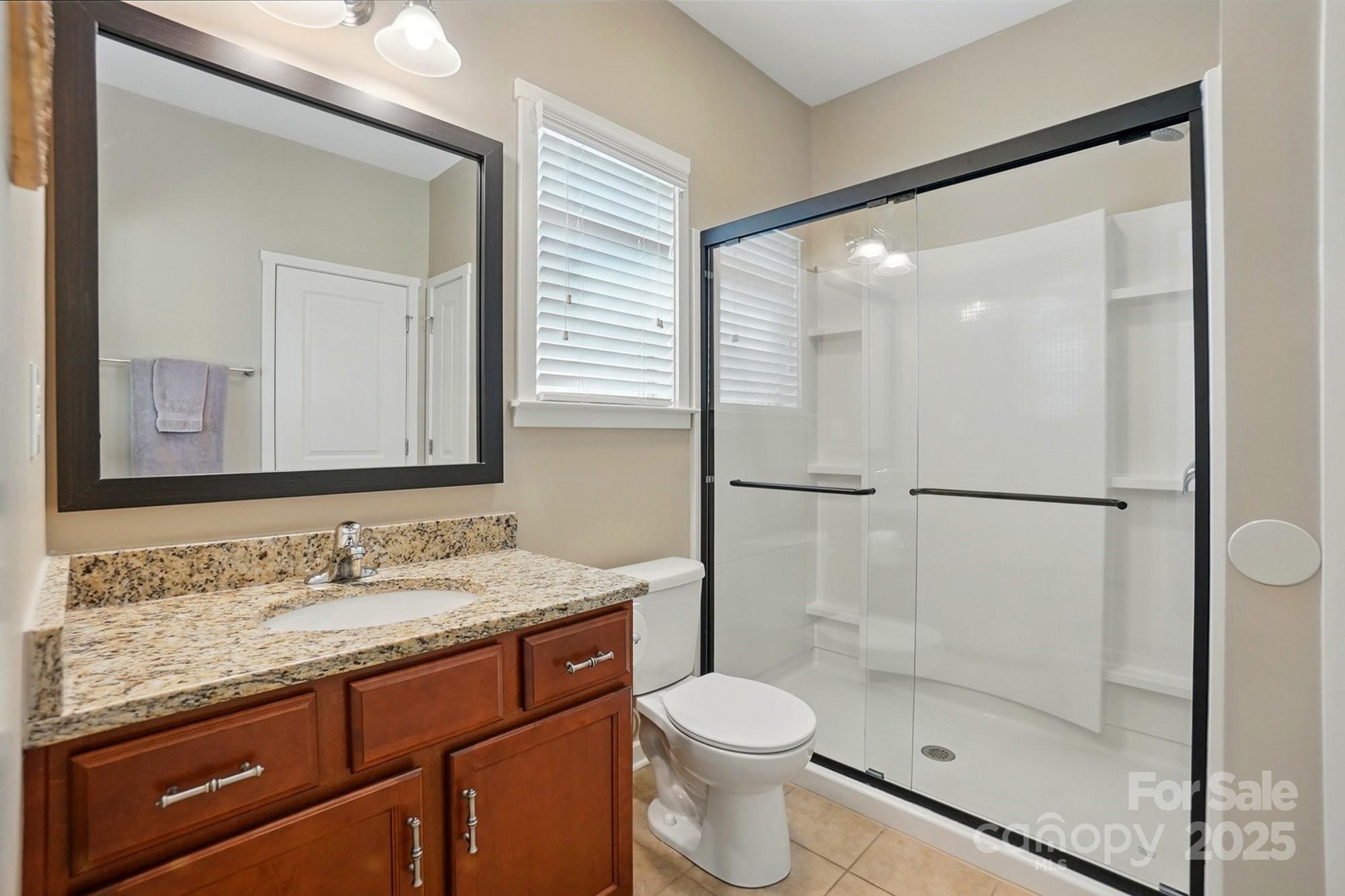 3106 Crosswind Drive Fort Mill, SC 29707 - Photo 24 of 43 a bathroom with a granite countertop sink toilet and shower