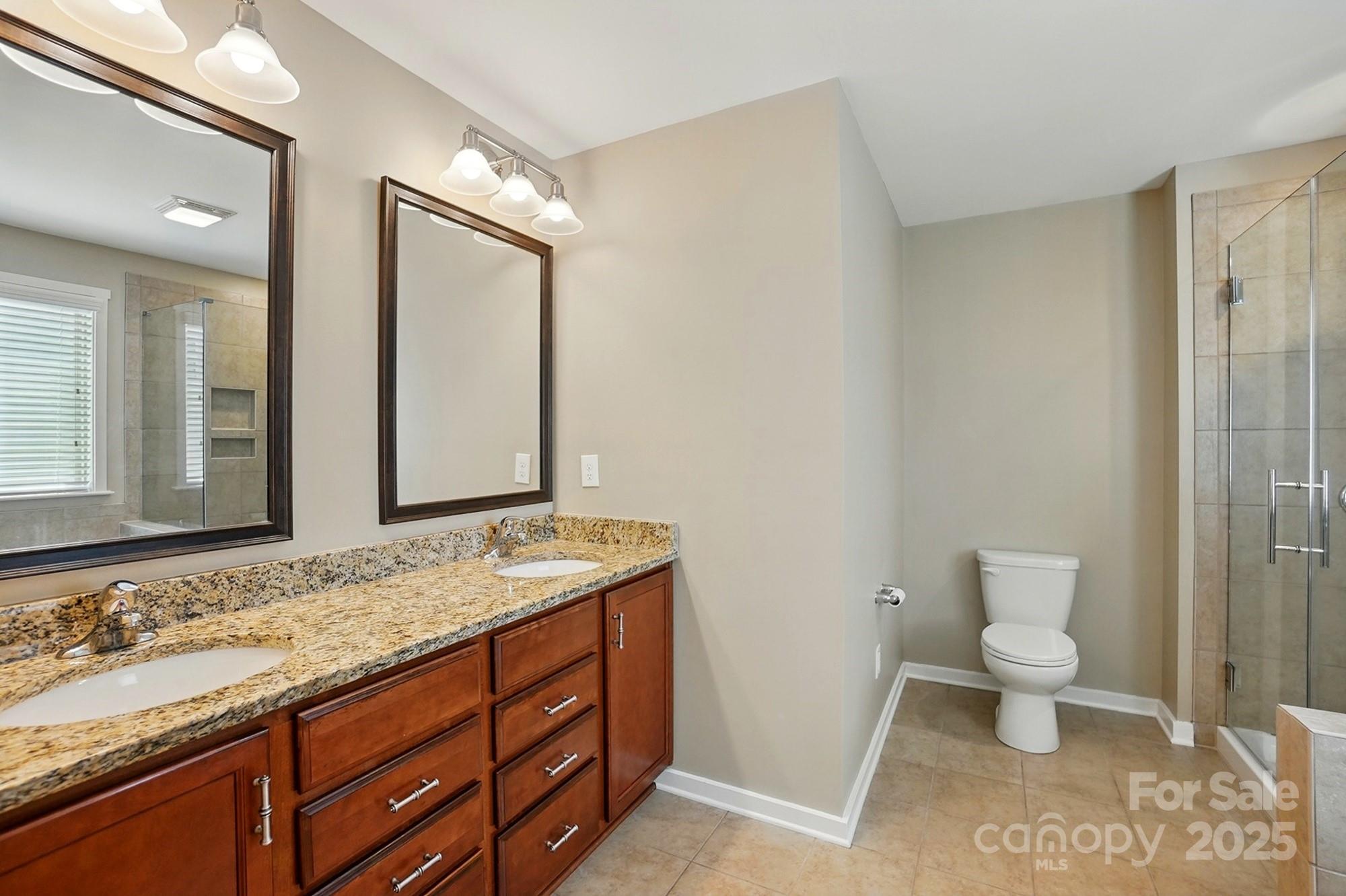 3106 Crosswind Drive Fort Mill, SC 29707 - Photo 28 of 43 a bathroom with a granite countertop sink mirror and a toilet