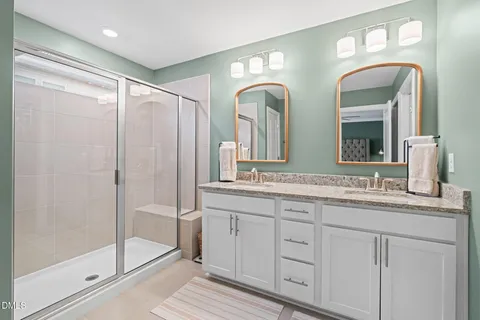a bathroom with a double vanity sink and a mirror