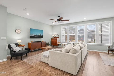 a living room with furniture a flat screen tv and a large window
